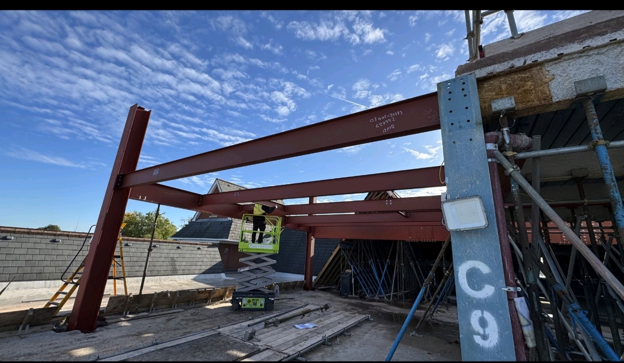 Steel columns and beams installed within scaffolded area
